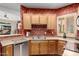 Traditional kitchen with wooden cabinets, stainless steel appliances, and decorative wallpaper at 1015 S Val Vista Dr # 81, Mesa, AZ 85204