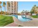 A luxurious pool area alongside a modern high-rise, featuring a spa and ample green space at 1040 E Osborn Rd # 404, Phoenix, AZ 85014
