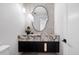 Modern powder room featuring a unique marble vanity, decorative mirror, and stylish pendant lighting at 10541 E Windrose Dr, Scottsdale, AZ 85259