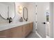 Modern bathroom with double sink vanity, white countertops, wood cabinets, and stylish mirrors at 10541 E Windrose Dr, Scottsdale, AZ 85259