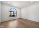 Bright and airy bedroom with hardwood flooring and a large arched window at 10541 E Windrose Dr, Scottsdale, AZ 85259