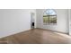 Minimalist bedroom with hardwood floors, large arched window, and natural light at 10541 E Windrose Dr, Scottsdale, AZ 85259
