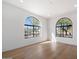 Bright bedroom with hardwood floors and arched windows offering scenic views at 10541 E Windrose Dr, Scottsdale, AZ 85259