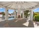 View of the poolside cabana with a fireplace that adds warmth and charm to outdoor entertaining at 10541 E Windrose Dr, Scottsdale, AZ 85259