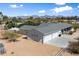 An aerial view of the home displaying the four car garage, additional shed, and mountain views at 11212 N Miller Rd, Scottsdale, AZ 85260
