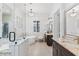 Bright bathroom features marble countertops, a soaking tub, glass-enclosed shower and a dark wood vanity at 11212 N Miller Rd, Scottsdale, AZ 85260