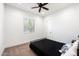 A cozy bedroom with a ceiling fan and a window bringing in natural light at 11212 N Miller Rd, Scottsdale, AZ 85260