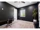 Modern bedroom with dark walls, carpeted floor, bright window, and desk with chair at 11212 N Miller Rd, Scottsdale, AZ 85260