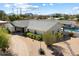 Expansive single-story home featuring desert landscaping, a swimming pool, and mountain views in the background at 11212 N Miller Rd, Scottsdale, AZ 85260