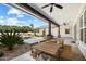 Spacious covered patio with outdoor dining table, ceiling fans and nearby pool at 11212 N Miller Rd, Scottsdale, AZ 85260