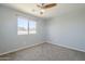 Carpeted bedroom featuring a ceiling fan, window, and neutral walls at 1236 E Mescal St, Phoenix, AZ 85020