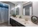 Stylish bathroom featuring double sinks, a dark vanity, and modern light fixtures at 13547 W Peck Dr, Litchfield Park, AZ 85340