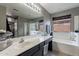 Bathroom featuring a large mirror, vanity, soaking tub, and tiled shower at 13547 W Peck Dr, Litchfield Park, AZ 85340