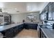 Functional kitchen with dark cabinets, granite counters, tile flooring, and natural light at 13547 W Peck Dr, Litchfield Park, AZ 85340