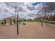 Playground area with swings, climbing structures, and a covered picnic area surrounded by sand at 13547 W Peck Dr, Litchfield Park, AZ 85340