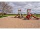Playground area with play structures, slides, and soft sand surfacing for outdoor fun and recreation at 13547 W Peck Dr, Litchfield Park, AZ 85340