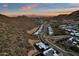 An aerial view showcases desert homes surrounded by mountains at sunset at 14715 N Adero Canyon Dr, Fountain Hills, AZ 85268