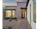 Modern home entrance featuring desert landscaping and a stylish, multi-paneled front door at 14715 N Adero Canyon Dr, Fountain Hills, AZ 85268