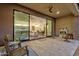Expansive outdoor patio with a fireplace and a view into the home's spacious kitchen and living area at 14715 N Adero Canyon Dr, Fountain Hills, AZ 85268