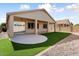 Covered patio extends to the backyard, with artificial grass and rock landscaping at 14994 W Charter Oak Rd, Surprise, AZ 85379