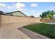 Artificial grass and desert landscaping in a private backyard with a block fence at 14994 W Charter Oak Rd, Surprise, AZ 85379