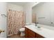 Bathroom featuring a seashell-themed shower curtain, wood vanity, and large mirror at 14994 W Charter Oak Rd, Surprise, AZ 85379