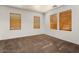 Bedroom featuring three windows with horizontal blinds and plush carpeting at 14994 W Charter Oak Rd, Surprise, AZ 85379