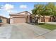 Home exterior with a large driveway, desert landscaping, and a two-car garage at 14994 W Charter Oak Rd, Surprise, AZ 85379