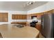Functional kitchen featuring wood cabinets, stainless steel appliances, and a breakfast bar at 14994 W Charter Oak Rd, Surprise, AZ 85379