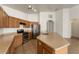 Well-lit kitchen with stainless steel refrigerator, gas range and central island with double sink at 14994 W Charter Oak Rd, Surprise, AZ 85379