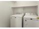 Bright laundry room with front load washer and dryer, shelf and ample space at 14994 W Charter Oak Rd, Surprise, AZ 85379