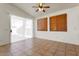 Open-plan living room with neutral tile floors, bright light, and large sliding glass doors at 14994 W Charter Oak Rd, Surprise, AZ 85379