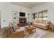 Bright living room boasts a cozy stone fireplace, built-in shelves, and large windows at 14994 W Charter Oak Rd, Surprise, AZ 85379