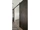 Stylish barn door with dark finish and unique hardware accents adding rustic charm to the interior at 15720 S 182Nd Ave, Goodyear, AZ 85338