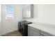 Functional laundry room featuring a washer, dryer, and ample counter space, perfect for chores at 15720 S 182Nd Ave, Goodyear, AZ 85338