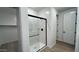 Modern glass shower featuring black trim in bathroom with walk-in closet at 15782 W Cheryl Dr, Waddell, AZ 85355