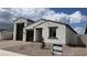 New build with stucco, brown accents, and a three-car garage with landscaping at 15782 W Cheryl Dr, Waddell, AZ 85355