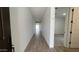 A long hallway with wood-look tile flooring leads towards a bright living space at 15782 W Cheryl Dr, Waddell, AZ 85355