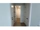 Bright hallway with white walls, wood-look tile, and doors leading to various rooms throughout the house at 15782 W Cheryl Dr, Waddell, AZ 85355