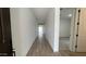 Bright hallway with sleek tile floors and neutral walls leading to a carpeted room, offering a clean transition at 15782 W Cheryl Dr, Waddell, AZ 85355
