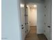 Bright hallway features wood-style flooring and multiple white doors with black hardware at 15782 W Cheryl Dr, Waddell, AZ 85355