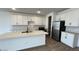 Bright kitchen with modern island, white cabinets, and stainless steel appliances at 15782 W Cheryl Dr, Waddell, AZ 85355