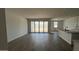 Open-concept living room with sliding glass doors and wood-style flooring at 15782 W Cheryl Dr, Waddell, AZ 85355