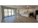 Expansive living room with sliding glass doors, light tile floors, and a kitchen with an island at 15782 W Cheryl Dr, Waddell, AZ 85355