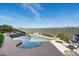 Enjoy this outdoor swimming pool complete with lush landscaping, rock features, and blue skies at 15830 E Eagle Crest Rd, Fountain Hills, AZ 85268