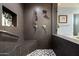 Modern shower with dark tiling, a built-in seat, shower niche, and glass enclosure at 15830 E Eagle Crest Rd, Fountain Hills, AZ 85268
