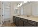 Bathroom with dual-sink vanity, stylish fixtures, and wood-look tile flooring at 17300 W Dahlia Dr, Surprise, AZ 85388