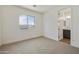 Carpeted bedroom featuring a window and an open doorway to the bathroom at 17300 W Dahlia Dr, Surprise, AZ 85388