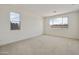 Bright, carpeted bedroom with two windows, offering natural light and neutral tones at 17300 W Dahlia Dr, Surprise, AZ 85388