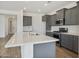 A contemporary kitchen with gray cabinets, a stainless steel microwave, and white countertops on an island at 17300 W Dahlia Dr, Surprise, AZ 85388